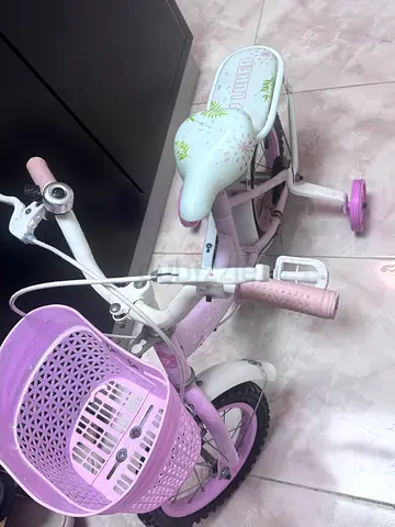 Kids pink white bicycle with training wheels and front basket - good condition