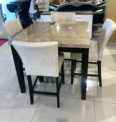 Elegant marble-top dining table with 4 comfortable padded chairs. طاولة طعام أنيقة بسطح رخامي مع 4 ك