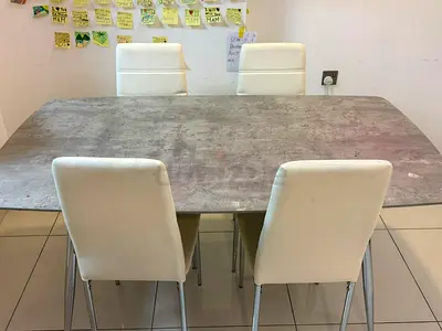 6-seater dining table with faux concrete top and white chairs