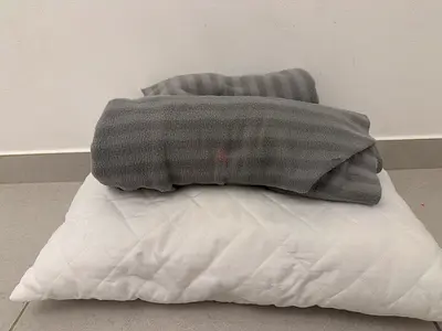 White pillow with grey blanket - used bedding set