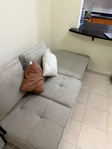 Grey 2-seater fabric sofa that converts into a straight 3 seat sofa bed.