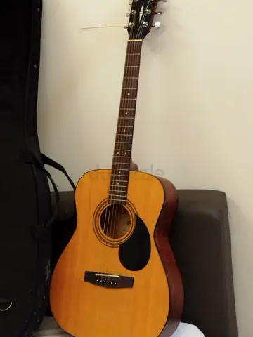Used acoustic guitar with soft gig bag - playable condition