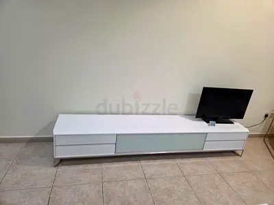 Long white low TV console with sliding door and drawers
