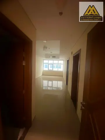 The apartment features a master bedroom with built-in wardrobes, central AC, and a prime location on a main road with easy access to Sharjah and Dubai