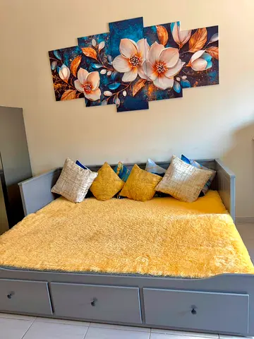 Grey IKea Hemnes daybed / Sofa bed with storage drawers, bedding and pillows.