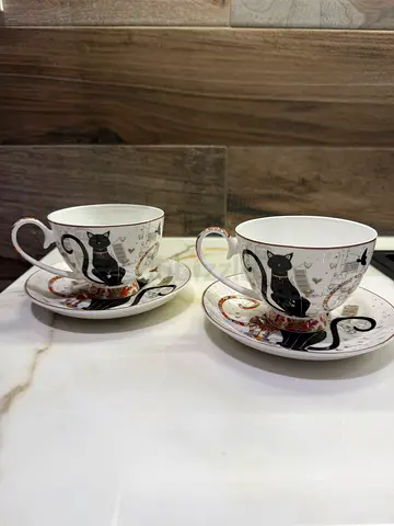 Pair of decorative porcelain teacups with saucers (black cat design)