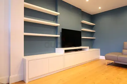Modern white low TV cabinet with wall-mounted shelving - good condition