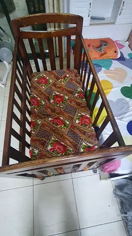 Wooden baby crib with floral mattress