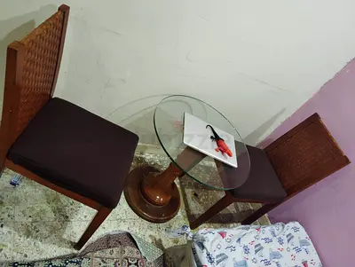 Pair of wooden chairs with rotating glass-top coffee table - good condition