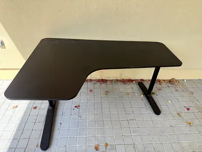 L-shaped black office desk — adjustable leg support, good condition