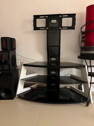 Black glass TV stand with wall-mount bracket and shelves