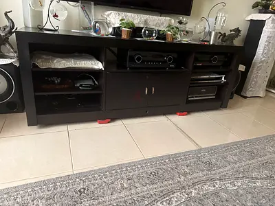 Dark wood TV entertainment unit with storage shelves and cabinets