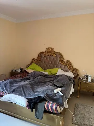Ornate king-size bed frame with tufted headboard and bedside tables