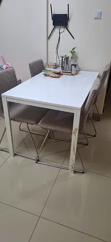 White dining table with 4 upholstered chairs - good condition 200 with  chair  covers