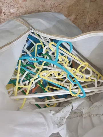 Bundle of plastic clothes hangers — mixed colors, used