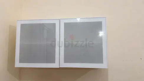 White wall-mounted storage cabinet with two glass-front doors