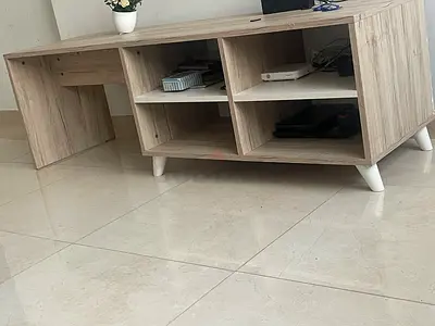 Light wood TV unit with open shelving and cable management
