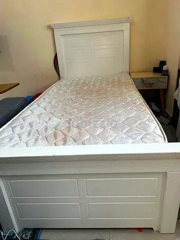 Single white wooden bed frame with mattress