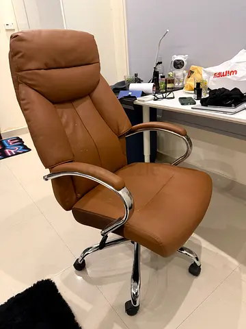 Brown leather ergonomic office chair with headrest and chrome base