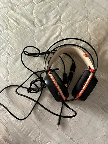 Wired over-ear headphones with worn ear pads and inline mic — needs repair