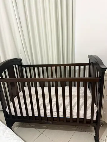 Dark wood baby crib, sturdy and in good condition with water proof mattress