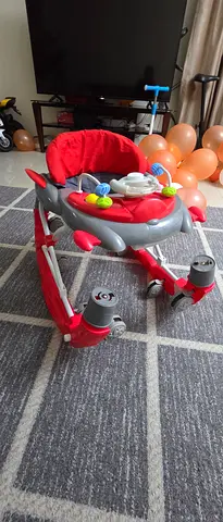 Red adjustable baby walker/rocker in good condition