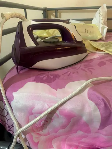 Purple and white steam iron for clothes
