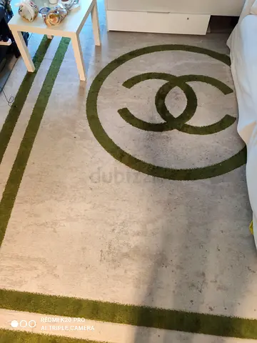 Light beige rug with green circular modern pattern - good condition