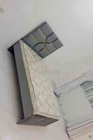 Single grey upholstered bed frame with headboard and mattress