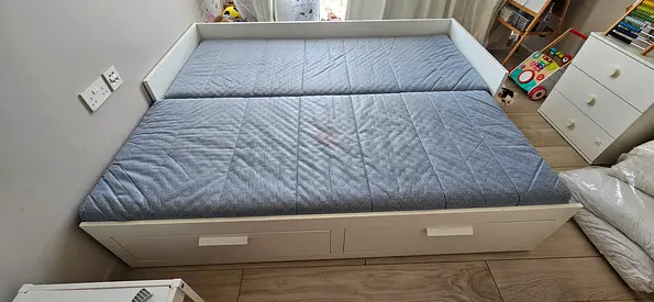 White wooden daybed with under-bed drawers and mattress