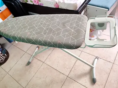 Adjustable ironing board with iron rest — good condition