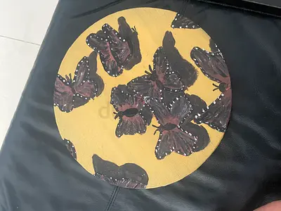 Hand-painted round wooden plaque with butterfly motif