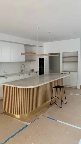 Modern kitchen island with marble top and slatted wood base
