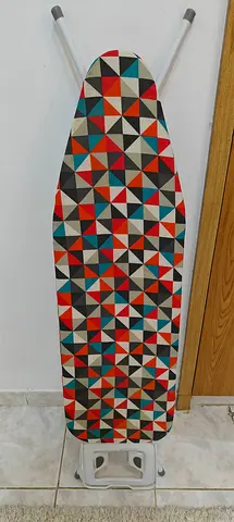 Used foldable ironing board with patterned cover - good condition