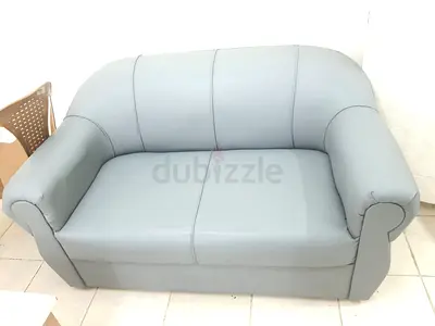 Two-seater light grey leatherette sofa in good condition