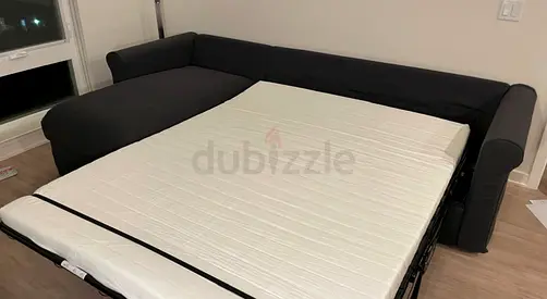 Dark grey L-shaped sofa bed with mattress - good condition