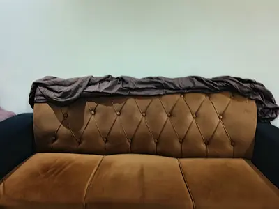 Brown two-seater upholstered sofa in good used condition