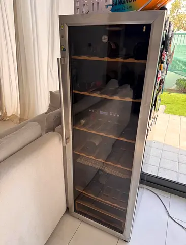 Hoover brand wine cooler with a stainless steel frame and glass door.The unit features internal wood