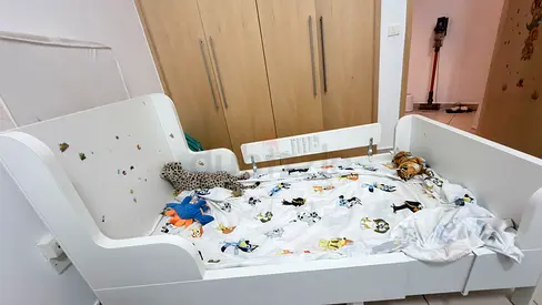White toddler bed with safety rails and mattress - good condition