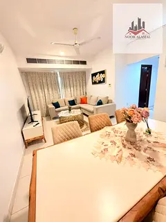 Sharjah, New Muwaileh, two-bedroom apartment with living room, kitchen, two bathrooms, and balcony.