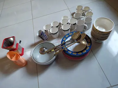 Assorted plates, bowls, mugs and serving utensils - used kitchen set
