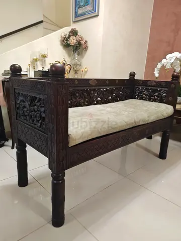 Ornately Carved Wooden Bench with Cushion