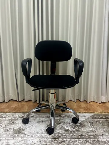 Black ergonomic office chair with armrests and wheels