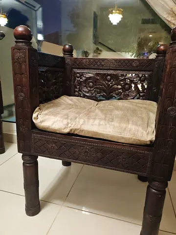 Ornately Carved Wooden Bench with Cushion