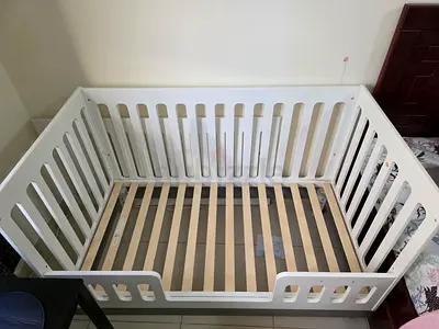 White wooden baby crib in good used condition. With attachments to convert hight and stile.