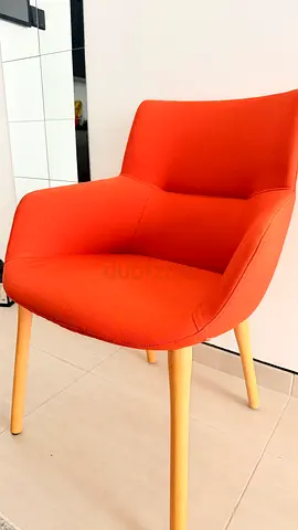 Comfortable orange upholstered accent chair with wooden legs