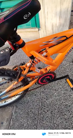Orange kids mountain bike with rear suspension - good condition