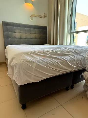 Grey upholstered queen bed with headboard