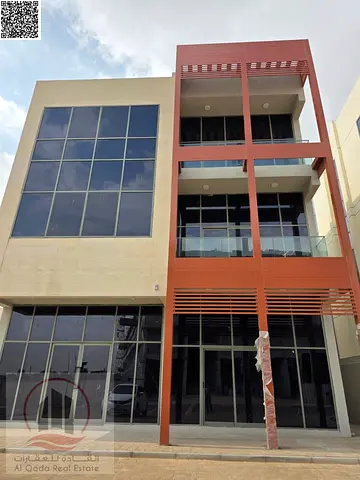 Commercial building for sale in Ajman, Al Tallah 2 area; consists of ground floor plus two upper floors, including electricity, water, and central air