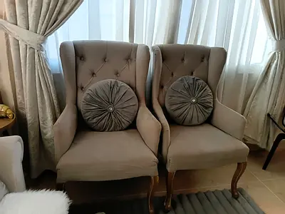 Pair of tufted wingback accent chairs with round cushions